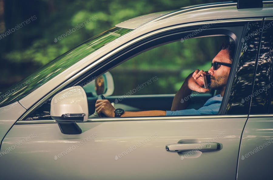 عکس مرد در حال صحبت با گوشی حین رانندگی