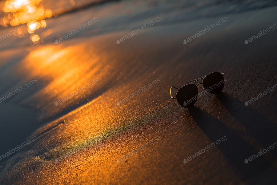 عکس عینک در غروب ساحل دریا