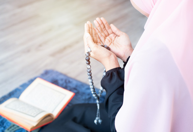 عکس دعا کردن زن هنگام خواندن قرآن