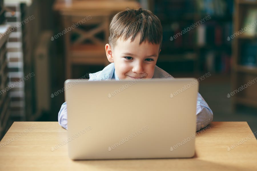 عکس کودک در حال تماشای کارتون با لپتاپ