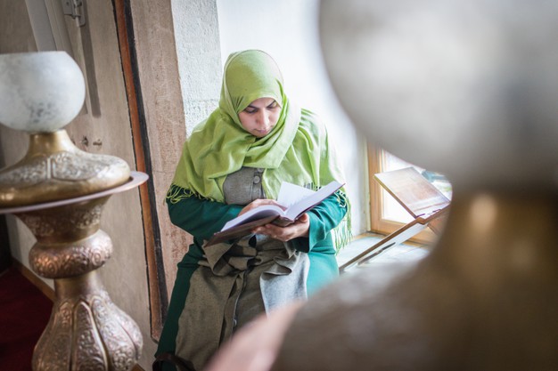 عکس زن محجبه در حال خواندن قرآن  در مسجد