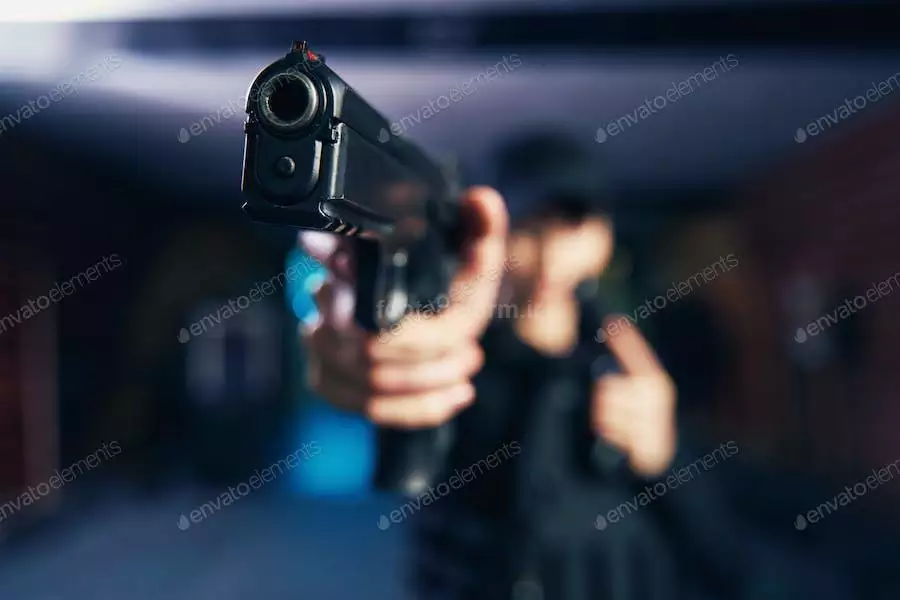 عکس مرد در حال نشانه گیری با اسلحه کمری