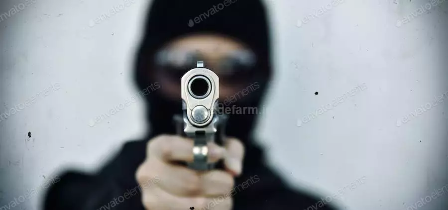 عکس دزد در حال شلیک با اسلحه کمری