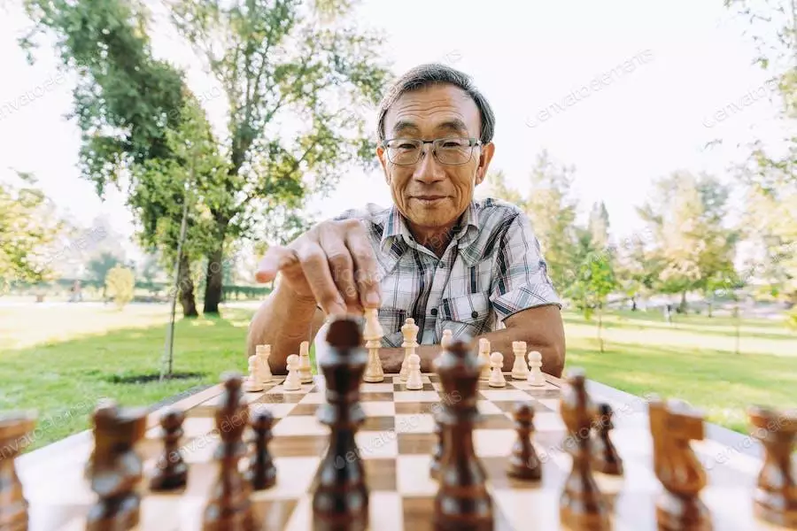 عکس مرد در حال شطرنج بازی کردن در پارک